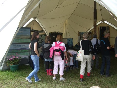 The photo shows visitors entering the Green tent
